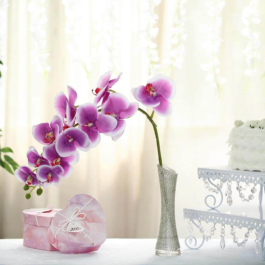 Orchid in a vase with decorative gift box in a bright, styled setting.
