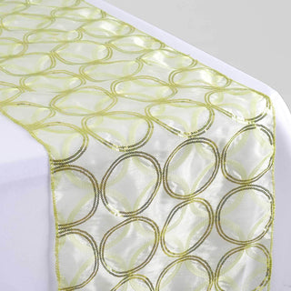 Sheer green and gold patterned table runner on a white table