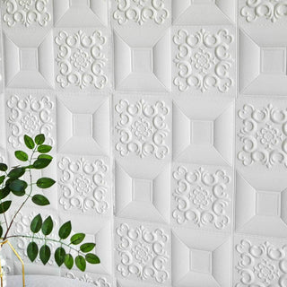 Textured white wall panels with intricate designs and a green plant in the foreground.