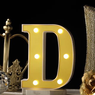 Yellow decorative letter "D" with lights on a dark background.