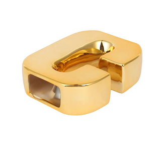 Gold letter "C" decorative object on white background