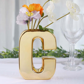 Gold letter "G" vase with flowers, perfect for home decor.
