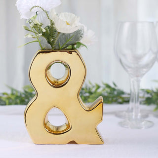 Gold ampersand vase with flowers, elegant decor accent for home or event.