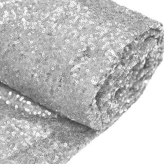 Rolled silver sequin fabric on a white background