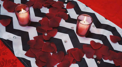 Black-and-white chevron runner with red rose petals and candles