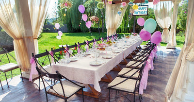 Outdoor birthday table under a draped canopy