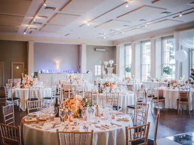 Reception tables with white tablecloths and floral centerpieces