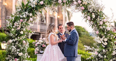 Wedding couple exchanging vows under a floral arch