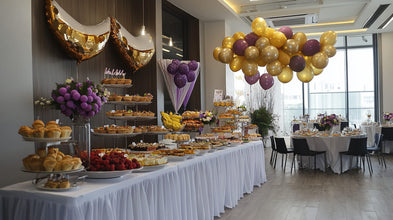 Elegant corporate event decor with gold balloons and purple flower centerpieces.