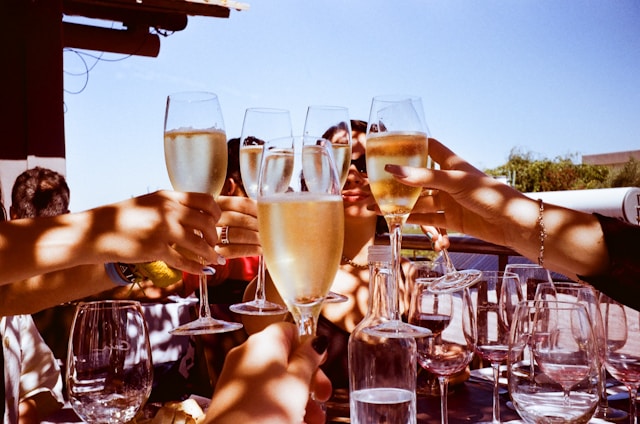 People toasting with champagne glasses at a corporate holiday party outdoors.