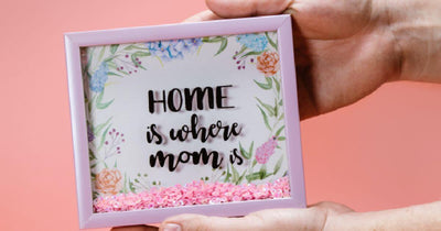 Framed floral sign reading “Home is where mom is”
