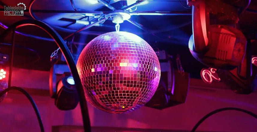 Disco ball illuminated by colorful lights, creating a vibrant party atmosphere.