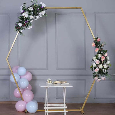 Hexagonal gold wedding arch with floral arrangements and balloons