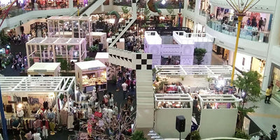 Indoor trade show with vendor booths in a shopping mall
