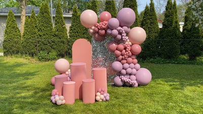 Pink balloon arch with sequin backdrop and cylinder stands