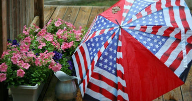 Patriotic umbrella beside pink flowers