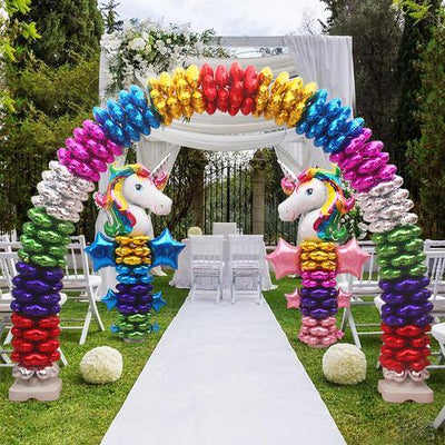 Rainbow unicorn balloon arch over an outdoor aisle