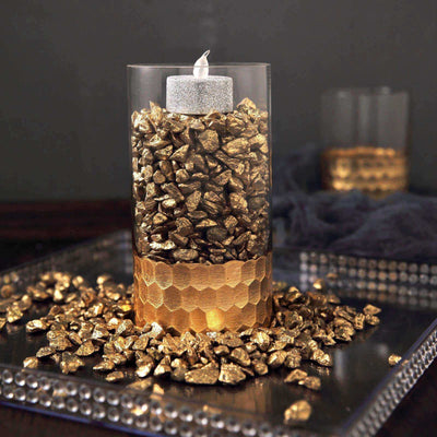Gold pebbles around a candle centerpiece