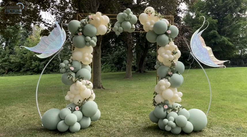 Finished fairy-inspired balloon arch with dusty sage green and beige balloons, adorned with floral accents.