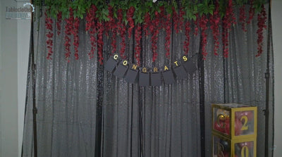Full view of sparkling curtain, balloon boxes, and congrats banner setup.