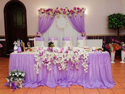 Lavender wedding reception table with floral backdrop