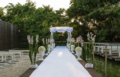 Outdoor wedding aisle under a draped gazebo