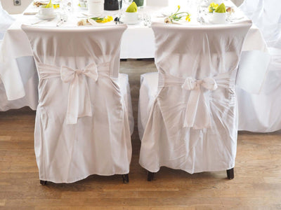 White chair covers with bows at a decorated table