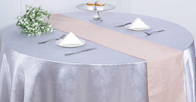 Round table with pale table runner and floral centerpiece