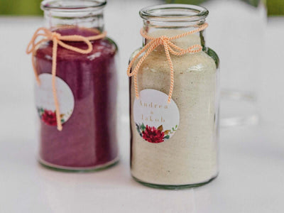 Two decorated jars filled with colored sand