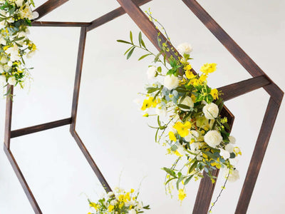 Homemade wooden wedding arch with yellow and white flowers