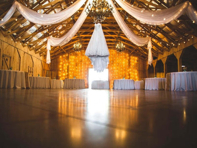 Wedding reception hall with draped ceiling and string lights