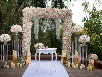 Floral wedding arch with chandeliers and candles