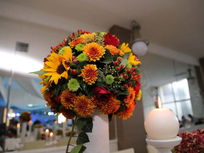 Sunflower and red flower arrangement on a pedestal