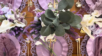 Overhead view of lavender table setting with purple plates and floral centerpiece.