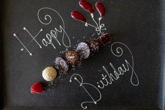 A creative dessert plate with 'Happy Birthday' written in chocolate.