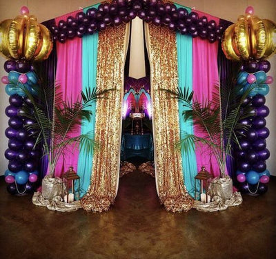 Arabian Nights-themed party entrance with balloons and gold drapes