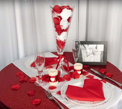 Red and white Valentine table setting with rose petals