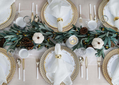 Fall table setting with olive garland and pinecones