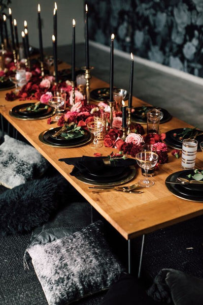 Dark tablescape with black candles and pink flowers