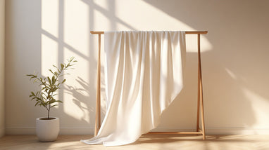 White linen fabric draped on a wooden rack.