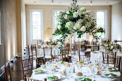 Round table with tall floral centerpiece at a wedding reception