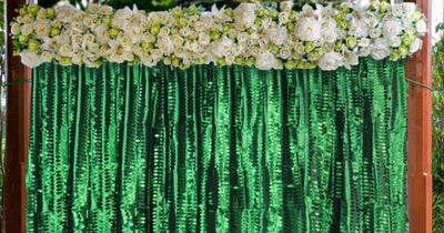 Floral pipe and drape backdrop with green fringe