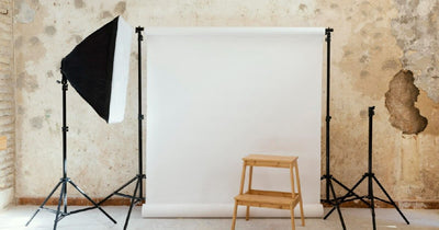 Photo studio backdrop with lighting stands and wooden stool