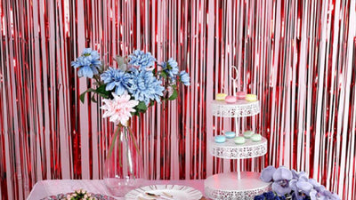 Pink fringe curtain backdrop with flowers and dessert stand
