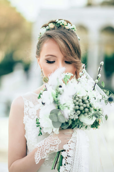 Bride holding a white and sage green bouquet