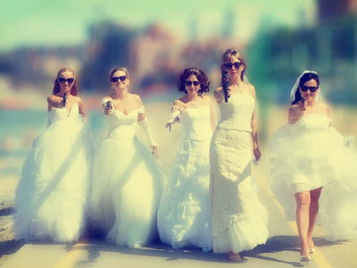 Bridesmaids in white dresses holding toy guns