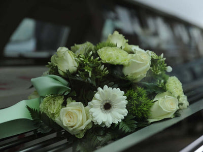 White funeral bouquet on a car windshield