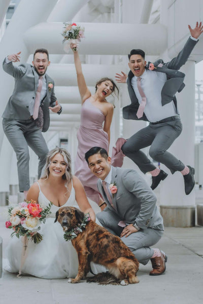 Wedding party posing with bouquets and dog