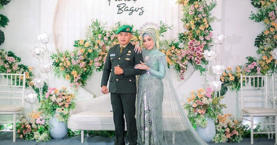 Couple posing on a floral wedding backdrop