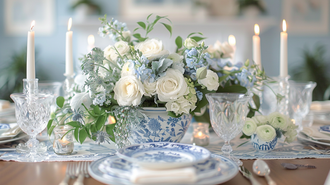 Blue and white tablescape with intricate dishware and floral centerpiece, accented by glowing candles for an intimate setting.